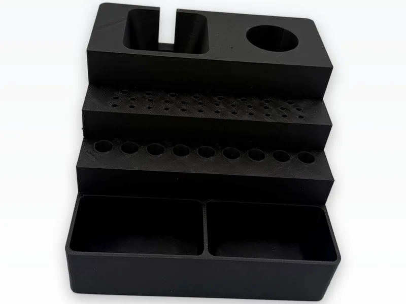 Black 3D printed rotary tool station with stepped bit holes and an open-top tray