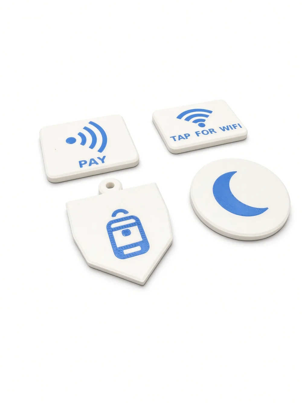 Four Formada3D NFC tags: Tap-to-Pay, Tap-for-Wi-Fi, sleep-mode disc and kids bag keychain tag, angled